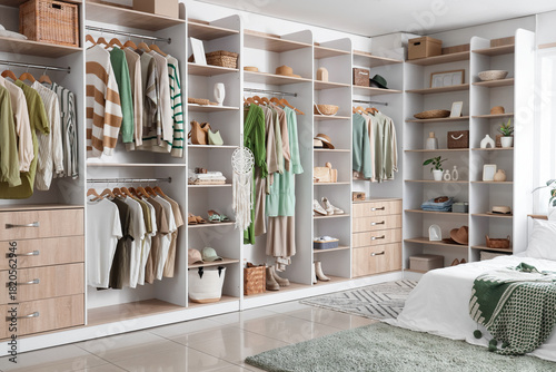 Wardrobe with stylish clothes and accessories in bedroom
