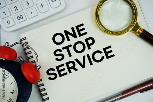 One Stop Service (OSS) text written on notepad with alarm clock, magnifying glass and calculator on white background
