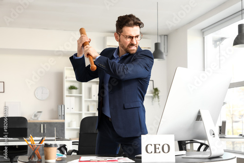 Angry businessman with bat ...