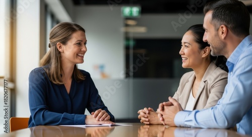 Teacher and parents conversing in office setting. Two women and one man engaging in positive discussion for team collaboration and corporate meeting.