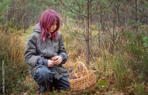 Young girl mushroom picking in autumn forest