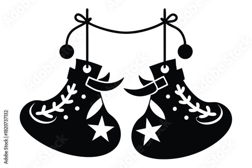 Two hanging decorated black shoes are suspended by a thread with white background