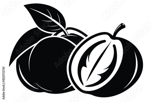 Two plums with leaves and one is cut in half show the core