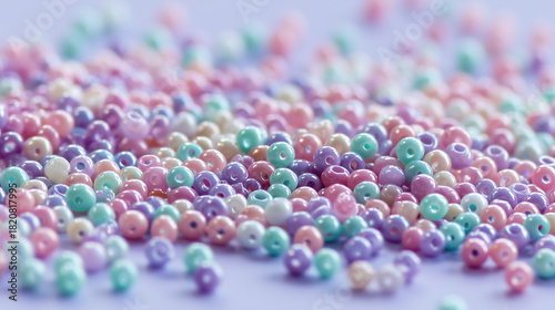 Colorful beads in pastel shades scattered on a light surface. The beads are round and glossy, creating a vibrant and playful scene.