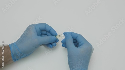 hands in blue gloves break a glass ampoule with medicine slow motion
