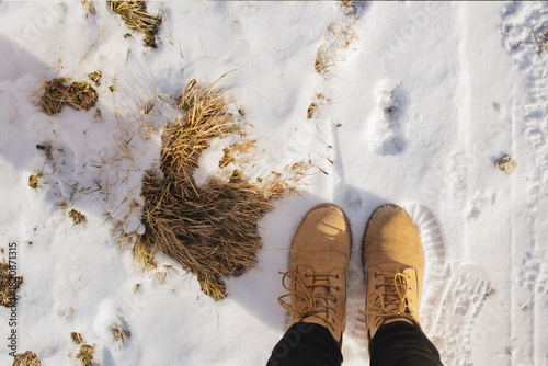 Hiking boots on snow top view in winter landscape