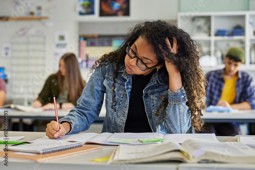 Tableau sur toile Tired african american student snorts while doing her homework