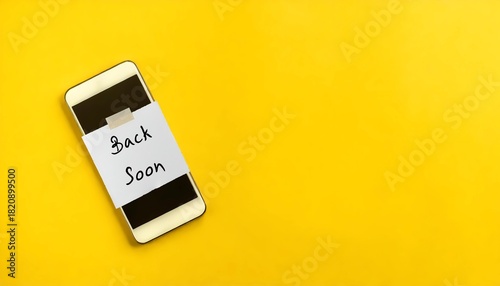 Mobile smartphone on copy space yellow background with note written Back Soon - Taking a break or switch off from social media, Offline disengage or deactivation, to detox and improve mental health