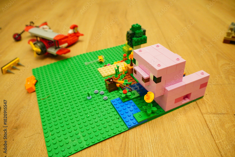 Fototapeta premium Minecraft pig and biplane toy scene built with colorful plastic bricks
