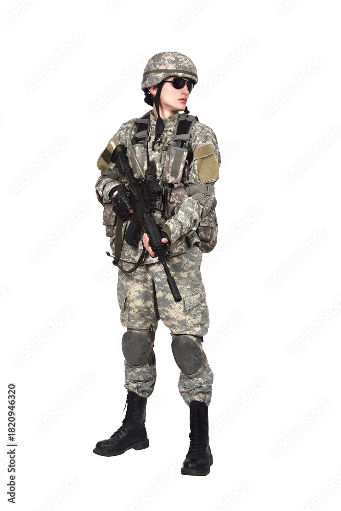 Fototapeta premium An American soldier in camouflage uniform, holding a rifle in his hands, turned his head to the side.