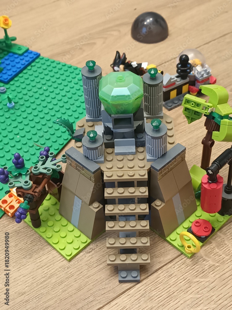 Obraz premium LEGO building blocks creating a fantastical structure with green crystal gem and futuristic elements