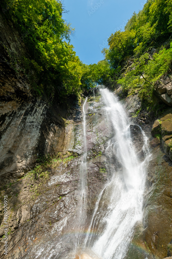 Obraz premium waterfall among mountain rocks and trees
