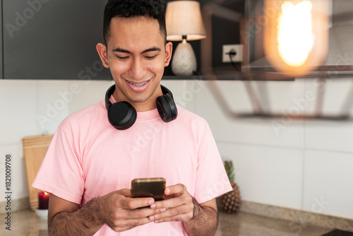 Mindful latino browsing smartphone in sustainable apartment
