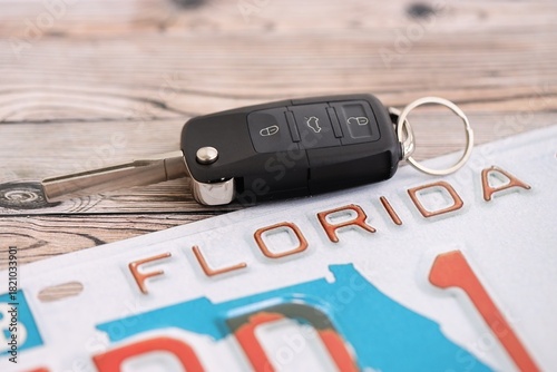 Remote control car keys on Florida license plate on wooden background. Concept of driving in Florida. Reaching a driving permit