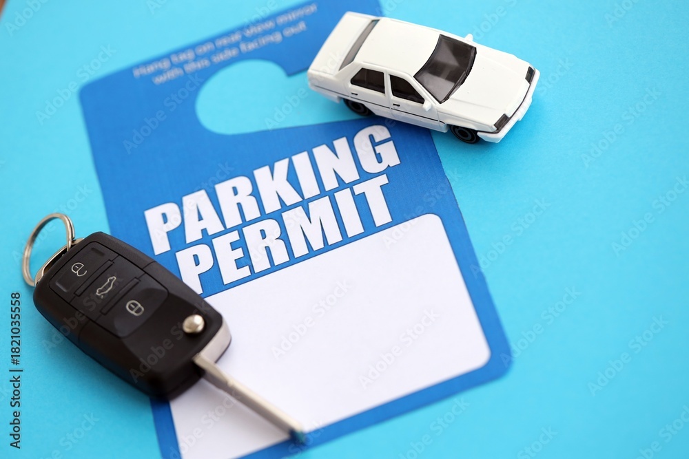 Obraz premium Parking permit paper notice tag for car interior with ignition keys and toy car. Parking permit for people with disabilities concept