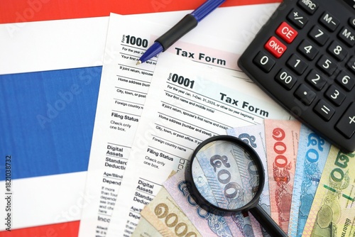 Thai baht money bills and calculator with tax form on flag close up. Taxation and accounting concept