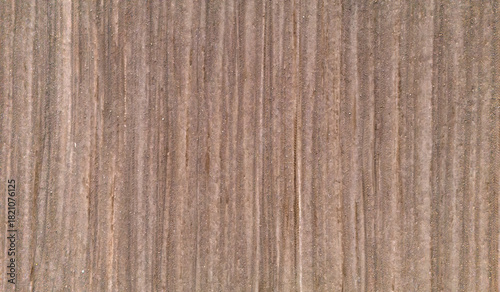 Vertical top down aerial texture of a ploughed soil field with straight vertical lines creating a minimalist natural background pattern for agricultural design