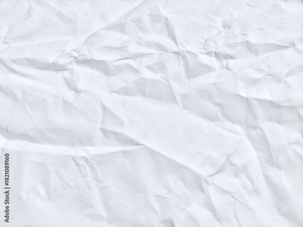 Naklejka premium Crumpled white paper texture featuring light creases and gentle shadows. White paper background with soft wrinkles and subtle folds.