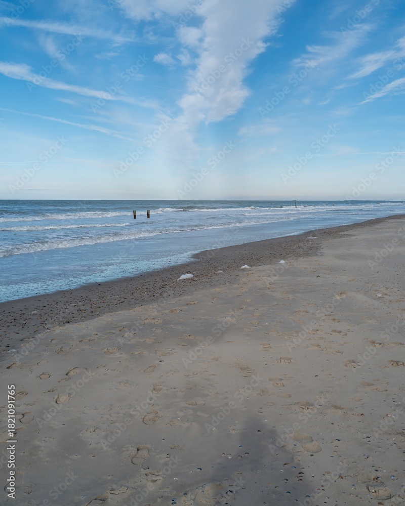 Fototapeta premium lonely beach with waves and sky in zeeland, the netherlands