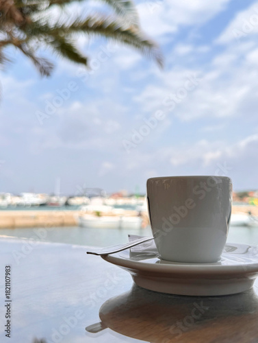 Fototapeta Naklejka Na Ścianę i Meble -  close up cup of coffee on table at a cafe view on the beach in Dalmatia, Croatia