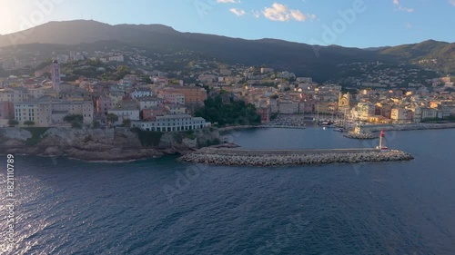 picturesque harbor during twilight hours, historic fortress overlooks tranquil water at evening. Bastia. France