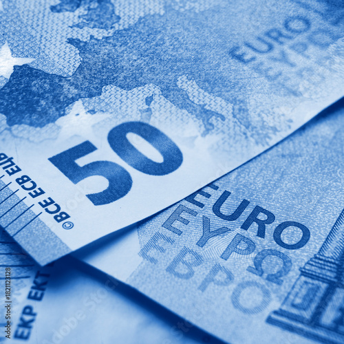 Closeup view and shallow focus  of 50 euro bills with europe map toned in blue