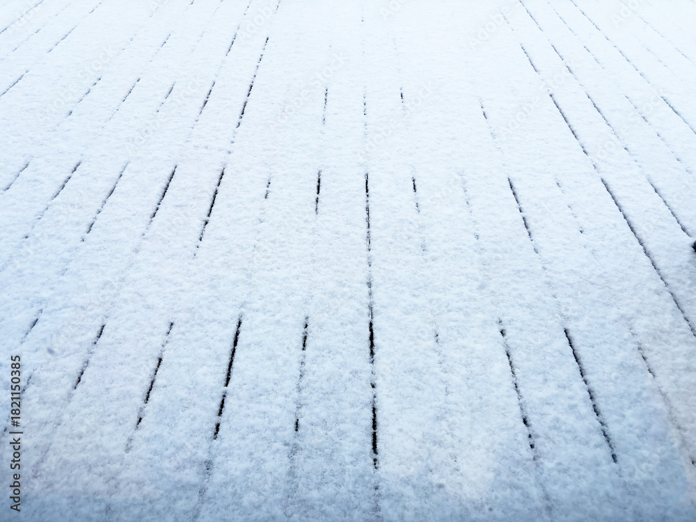 Obraz premium Snow-covered wooden walkway in winter, textured planks under a thin layer of fresh white snow creating a minimalistic clean seasonal background for cold weather and holiday concepts