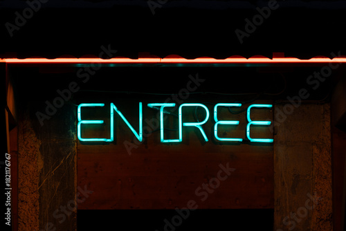 Neon blue entree shining on building at night