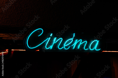 Neon cinema sign glowing at night