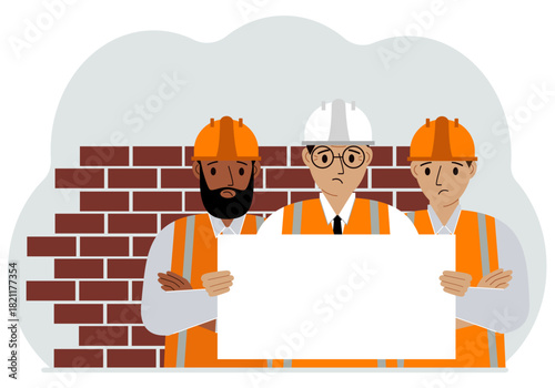 Construction team holding a white sheet of paper for text. Brickwork next to him.