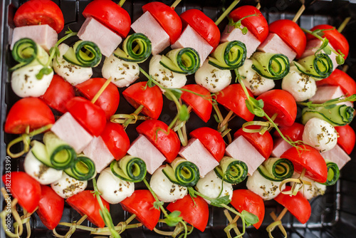 Принти на полотні Caprese skewers with mozzarella, tomato, cucumber and ham for party catering