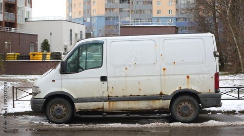 An old, rusty white minibus is parked in the courtyard of a residential buildingб Podvoyskogo Street, Saint Petersburg, Russia, November 25, 2025