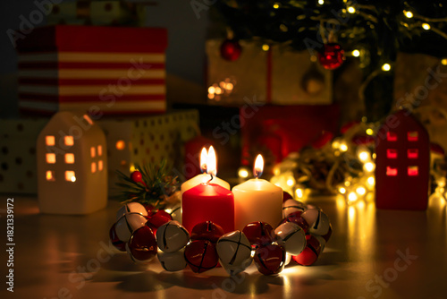 Christmas decorations: gifts wrapped in paper, candle, Christmas baubles and ornaments, and a garland glowing with warm light.
