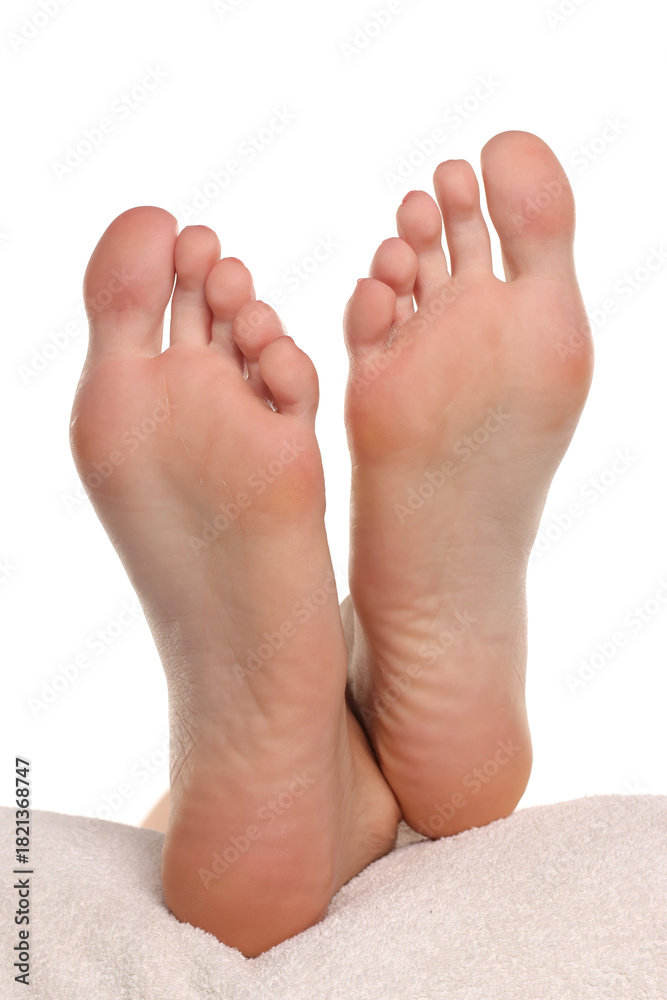 Fototapeta premium Close-up of a woman’s bare feet resting on a towel with clean smooth skin, concept of footcare and wellness, studio shot on a white background.
