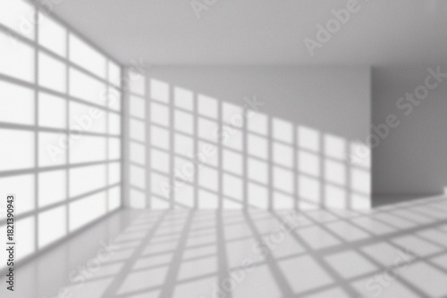 An empty room with light and shadow play. The scene showcases a modern architectural design, highlighting a bright, open space with sunlight casting grid patterns on the floor and walls