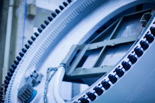 Close-up of a large circular industrial gear inside a manufacturing facility. The image highlights engineering, machinery, and heavy industrial components. Wind turbine.