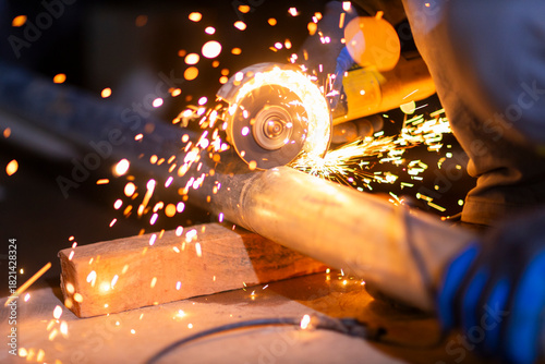 Tablou pe pânză Close-up of a worker using an angle grinder on metal, producing bright sparks