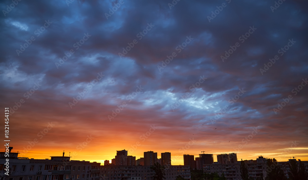 Naklejka premium Spectacular panoramic sunset sky over a city skyline.