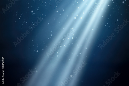 Gentle light rays with magic floating snow. Winter night background with snowflakes. Blue magic lighting scene.