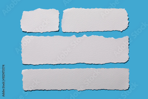 Strips of white torn paper on blue background