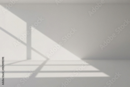 A sunlit room with window shadows, creating a minimalist and serene atmosphere. Shadows and light play across the wall and floor, giving a simple yet elegant visual