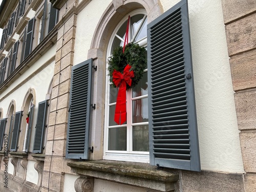 weihnachtliches Sprossen Fenster mit Holzjalousie und grünem Weihnachtskranz