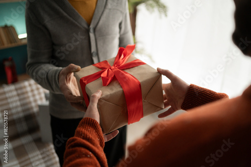 Male hands handing present box to senior man