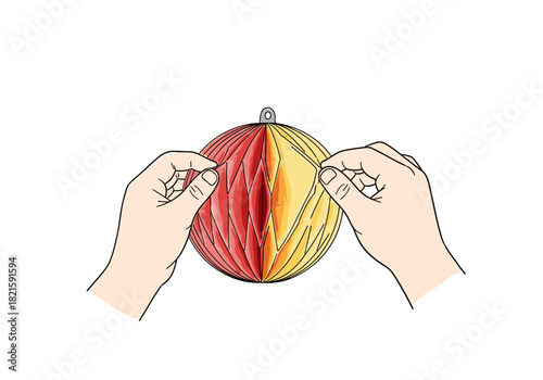 Two hands assembling a red and yellow paper honeycomb ornament  