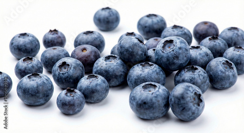 Fresh blueberries scattered on a clean white surface, showcasing their vibrant blue color and plump texture.