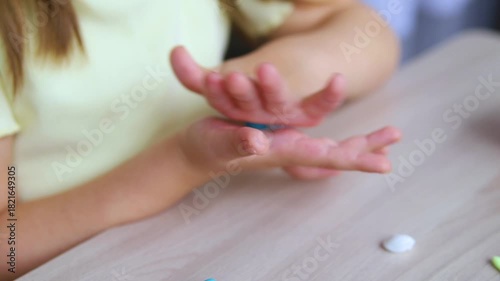 A little girl makes figurines out of colored airy plasticine, modeling dough. Hobbies for children's creativity, educational activities, development of fine motor skills of hands.