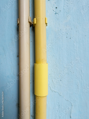 PVC electrical conduit pipes attached on house wall for wiring installation.