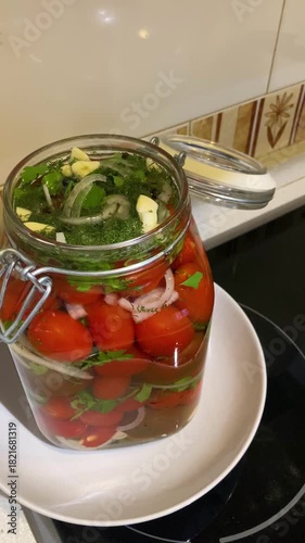 Homemade pickled tomatoes with parsley, onion, and garlic create a vibrant, aromatic blend of fresh herbs and savory brine.