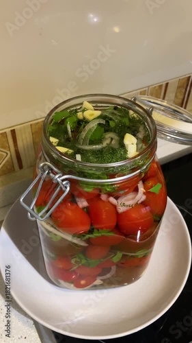 Homemade pickled tomatoes with parsley, onion, and garlic create a vibrant, aromatic blend of fresh herbs and savory brine.