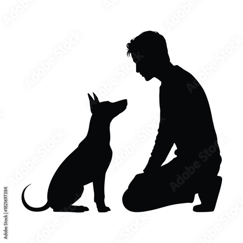 Silhouette of a man kneeling and looking at a dog